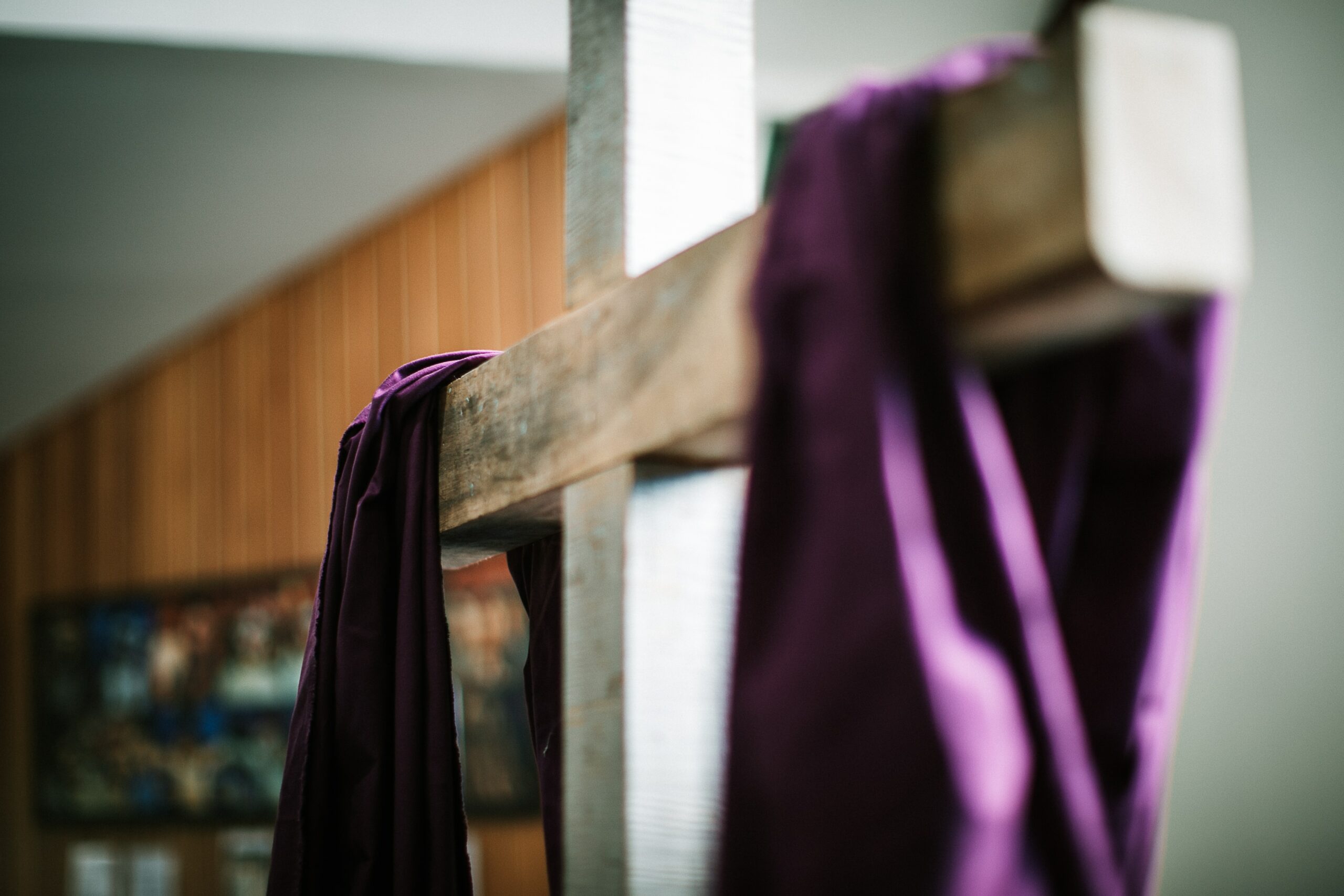 Wooden cross with a purple drape.